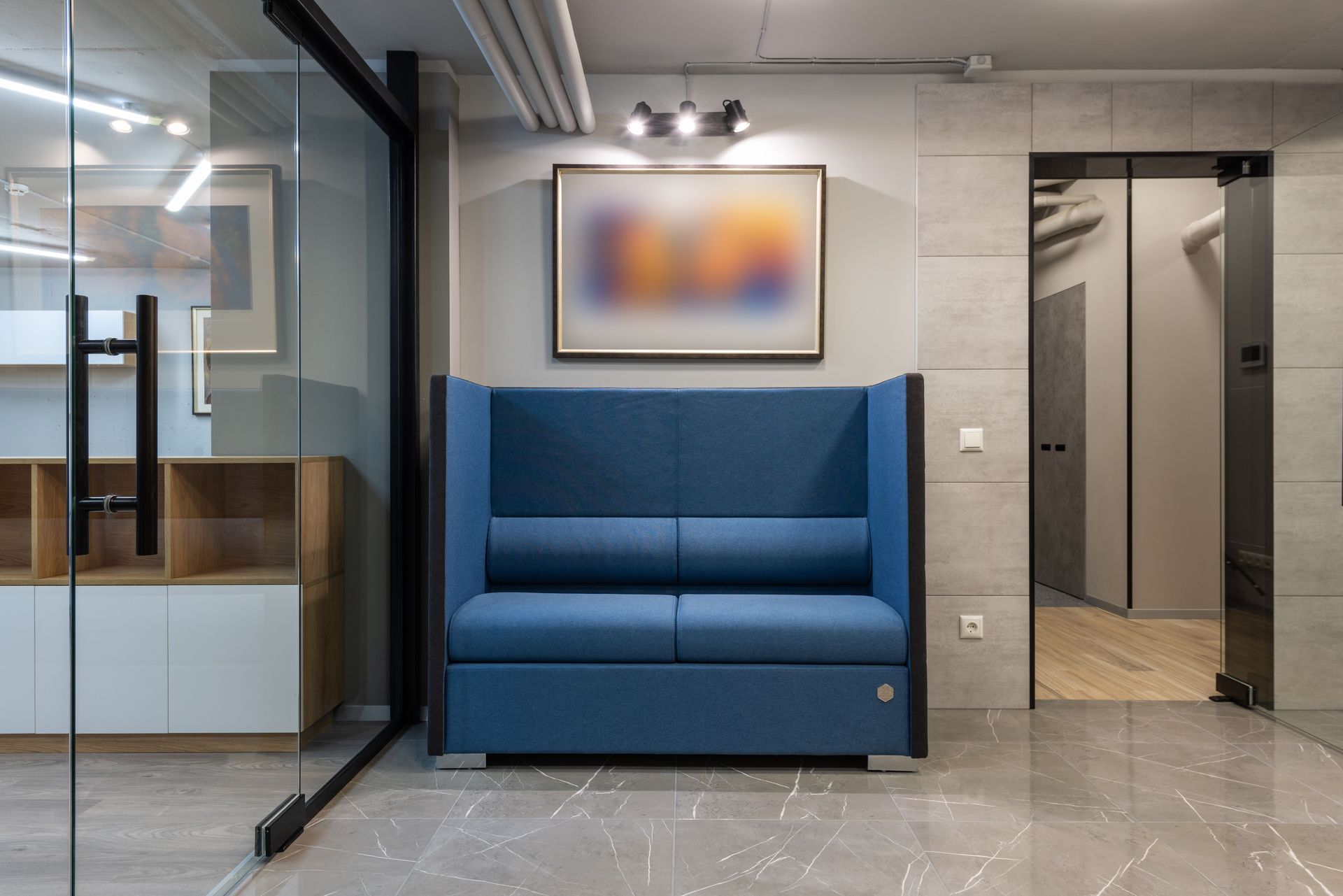 Interior of contemporary spacious hall with comfortable sofa placed on tiled floor in workspace